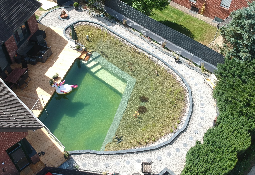 Fertiger Schwimmteich mit Terrasse von oben