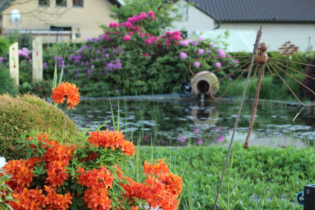 Figur einer Libelle am Rohrkolben