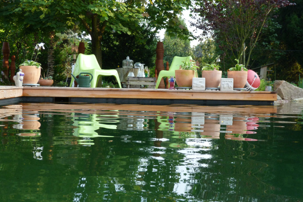 Gemütlich dekorierte Terrasse am Schwimmteich. Boje Schwimmsymbole und andere dekoelemente