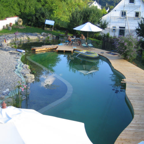 Entdecken Sie einen individuellen Schwimmteich in Hanglage bei Tuttlingen, selber gebaut mit Mielke's Schwimmteichfolie.