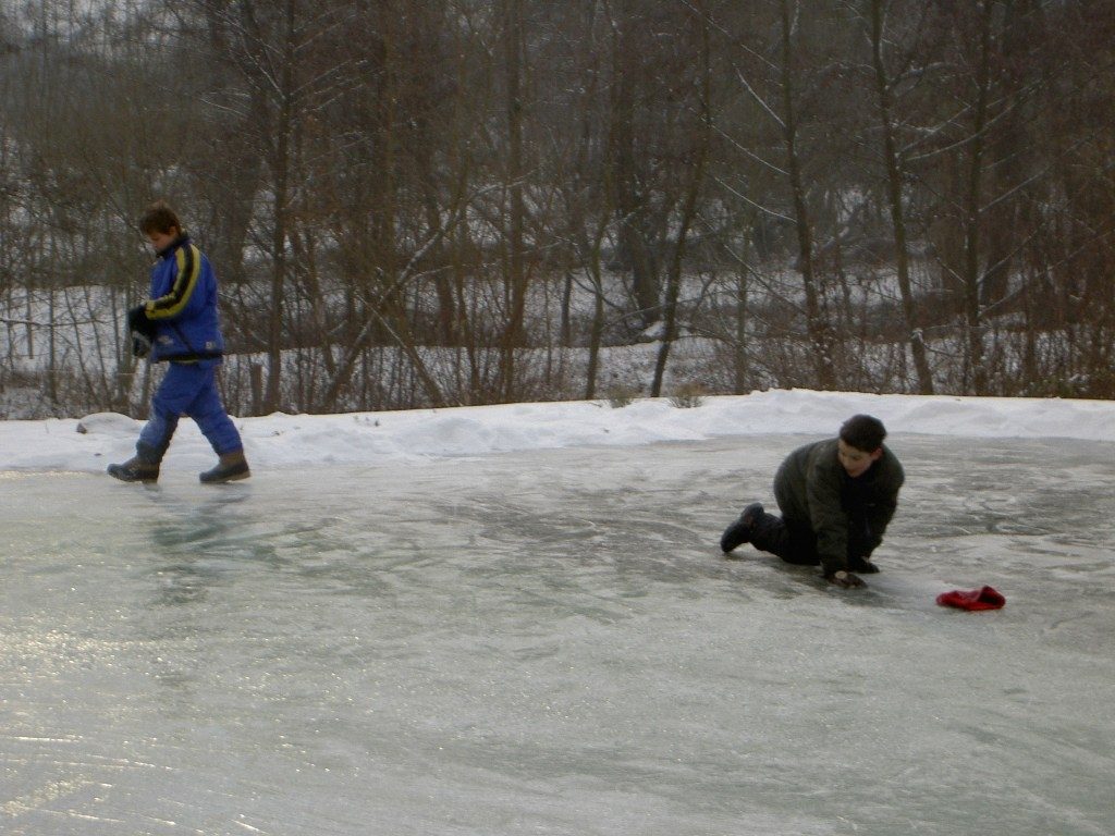 Schlitterspaß auf zugefrorenem Teich