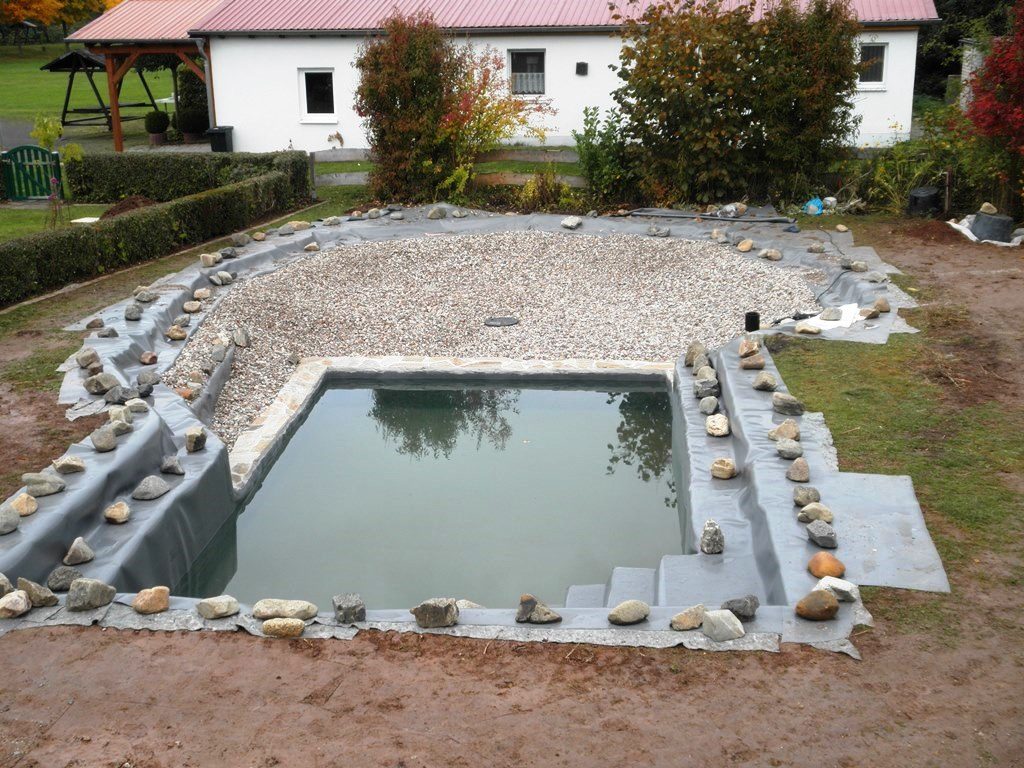 Schwimmbereich mit Wasser befüllt. In der Pflanzzone wurde der Kies verteilt. Die Folie wurde rundum an den Rändern mit Steinen beschwert.