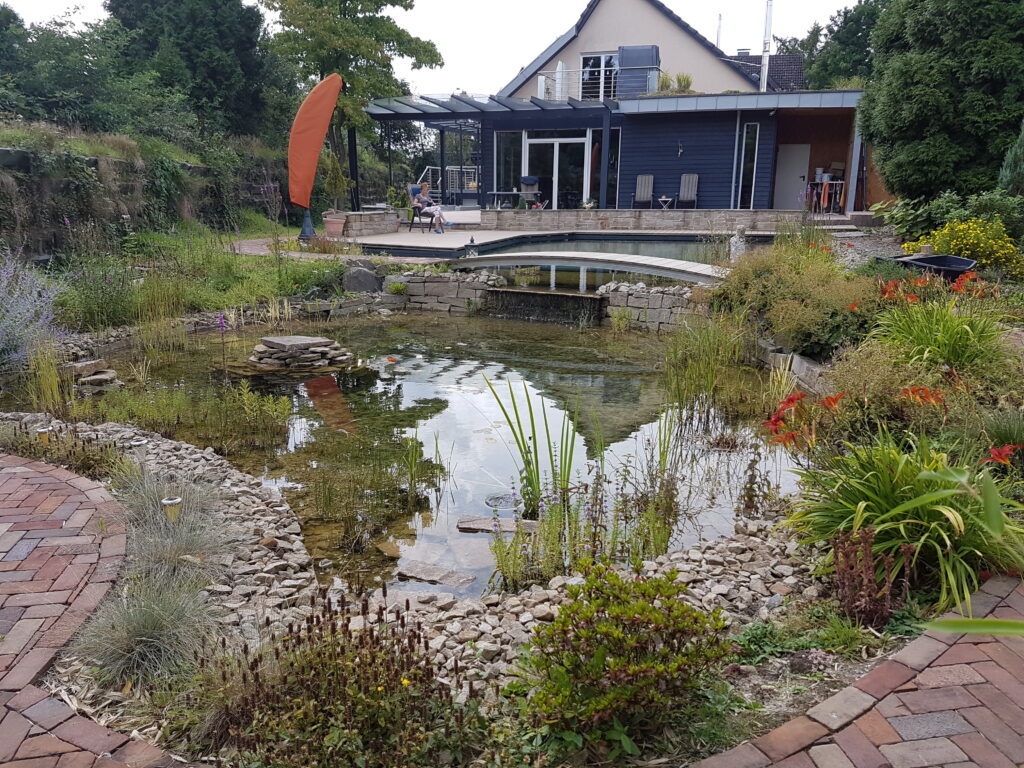 Fertiger Schwimmteich mit Brücke, Holzterrasse und Wasserfall