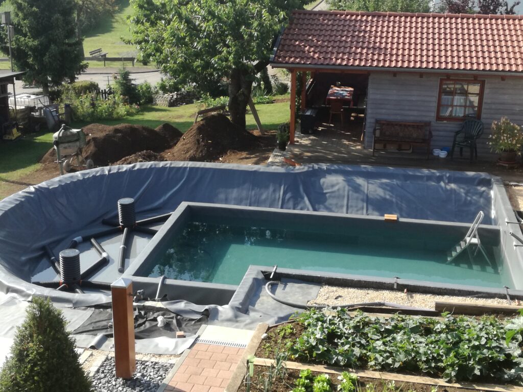 Schwimmbereich mit Wasserfüllung und Drainagetöpfen – Ein Blick auf den fast fertigen Schwimmteich.