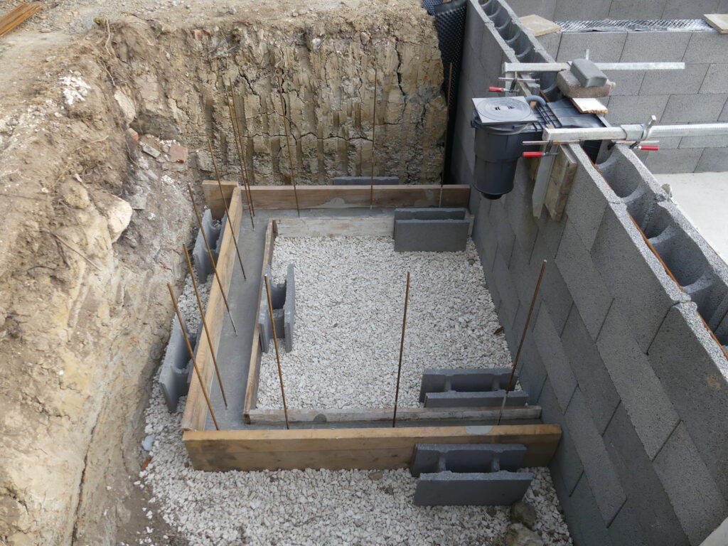 Vorbereitung des Technikbereichs mit Beton und Skimmervorrichtung, Holzbrettergrenze.