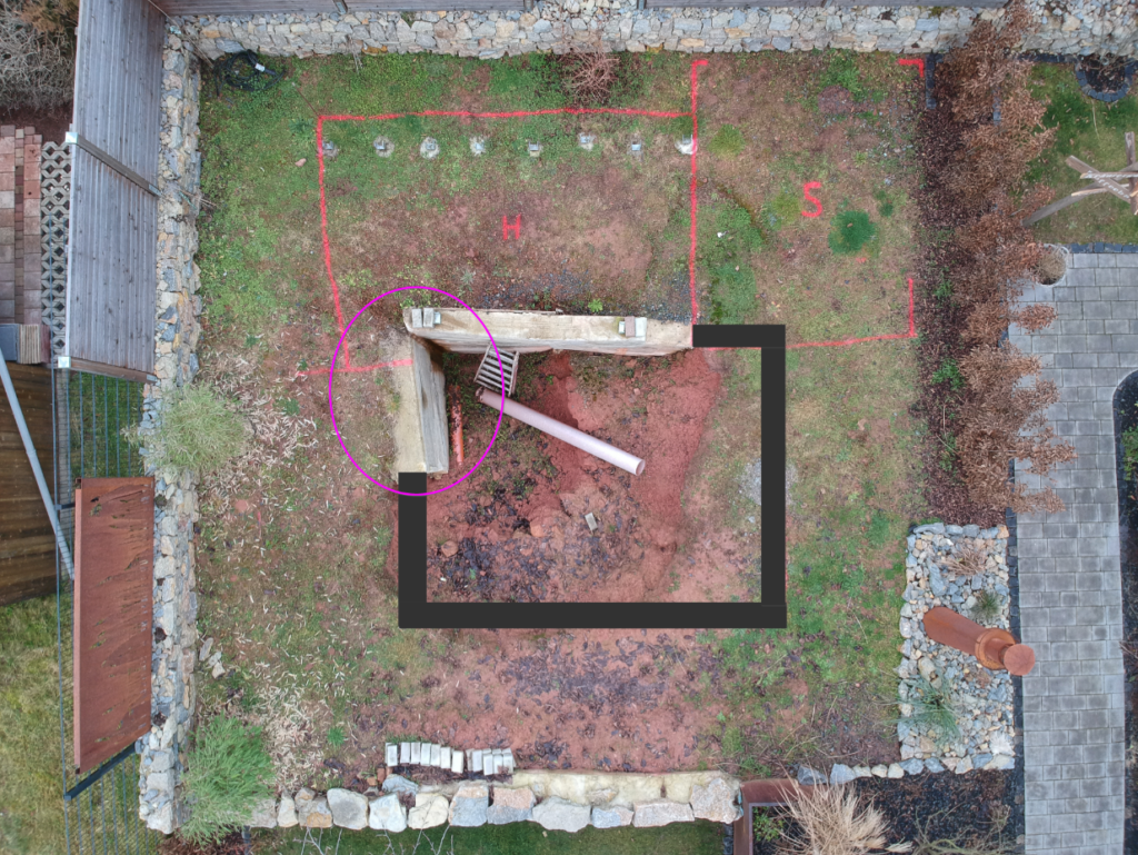 Luftaufnahme des Gartens mit einem aufgezeichneten Schwimmteich. Ein Rohr ragt aus einem Kiesbett heraus, Teil des Selbstbau-Projekts von Mielke's Naturbadeteich.