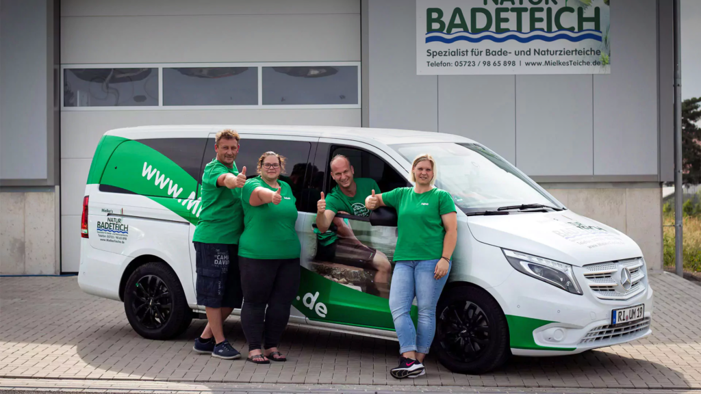 Teambild der Mitarbeiter von Mielke's Naturbadeteich vor einem Auto