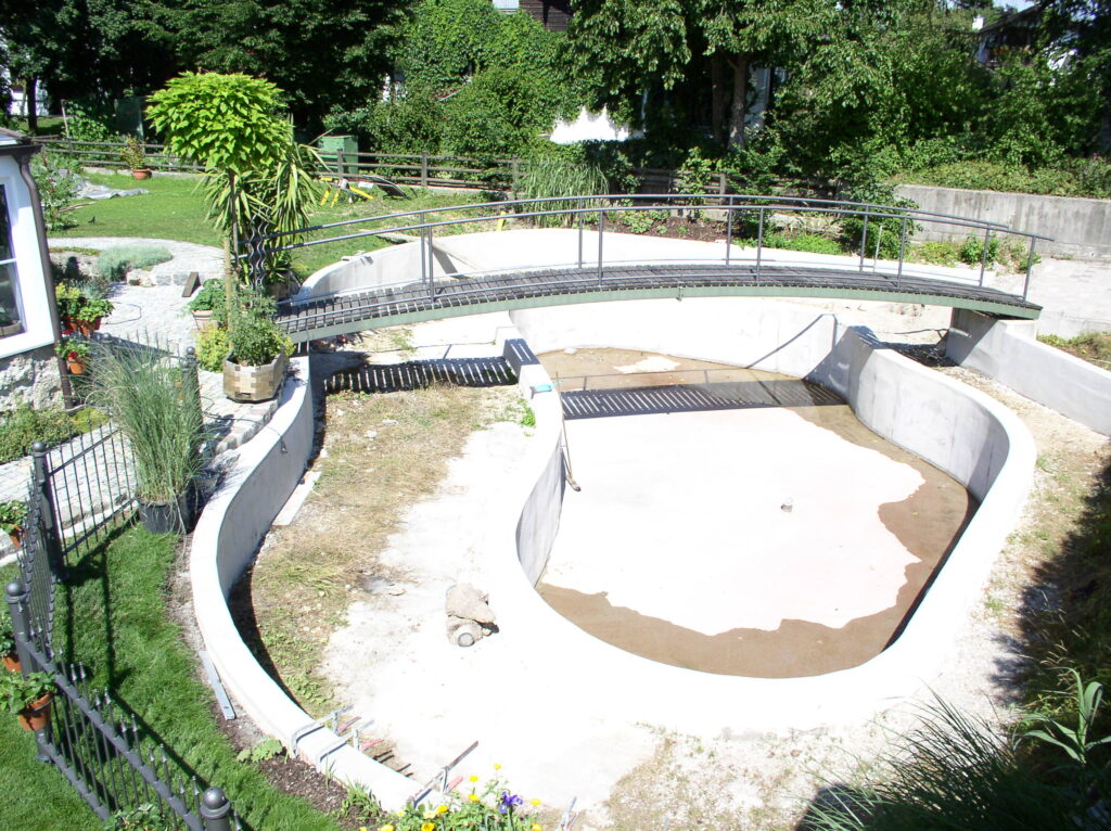 Gemauerter Schwimmteich im Garten in eigenwilliger Form.
