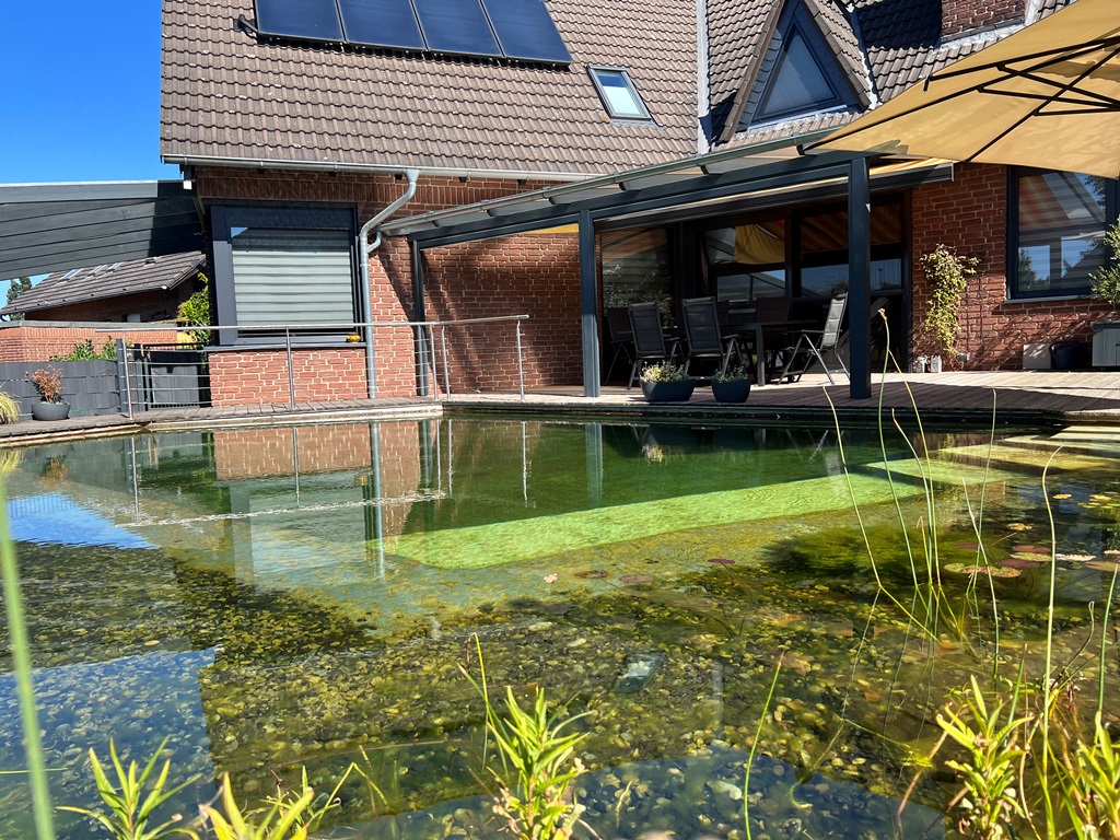Bild zeigt die stilvolle Terrasse mit Überdachung am Schwimmteich von Mielke's Naturbadeteich.