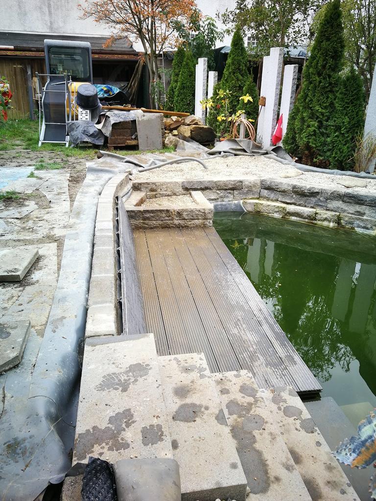 Holz-Liegefläche am Schwimmteich bei Stuttgart. Mit Rückenlehne lässt es sich im Wasser entspannen.
